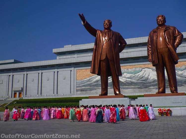North Korean women bowing in traditional clothing to statues Kim il-Sung and Kim Jong-il Pyongyang